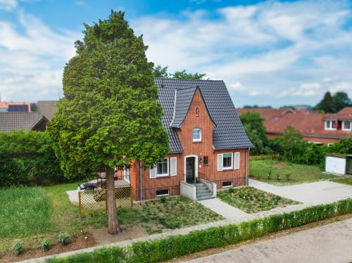 a house with a tree in front of it at Das Schneckenhaus EG in Lathen
