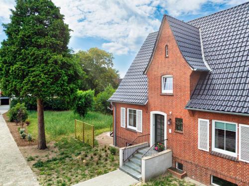 a red brick house with a black roof at Das Schneckenhaus EG in Lathen