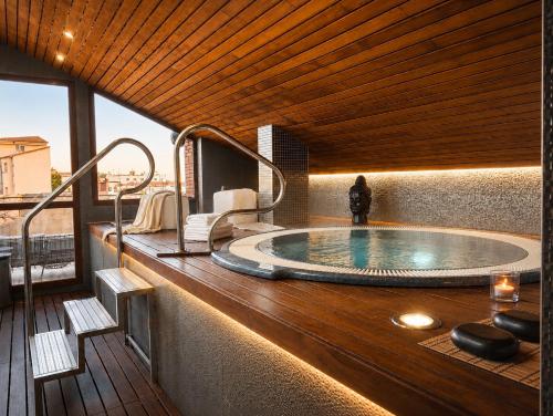a hot tub on the deck of a hotel room at Hotel Sancho Abarca Petit SPA in Huesca