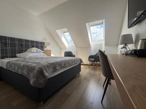 a bedroom with a bed and two windows at Stary Tartak in Iława