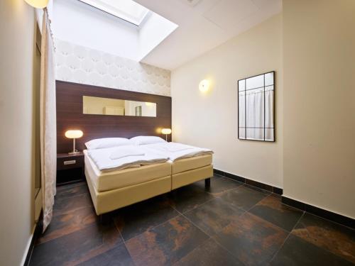 a bedroom with a large bed and a skylight at Rezidence Fontána in Teplice