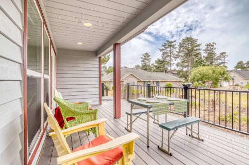 a patio with chairs and tables on a balcony at Twin Rocks Beach House in Rockaway Beach