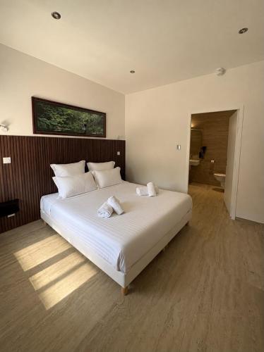 a bedroom with a large white bed in a room at Rovotel - Le Rove in Le Rove