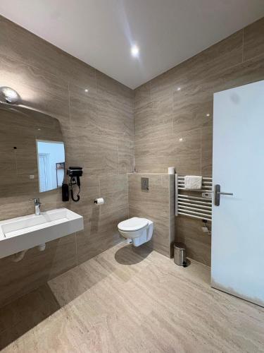a bathroom with a toilet and a sink and a mirror at Rovotel - Le Rove in Le Rove