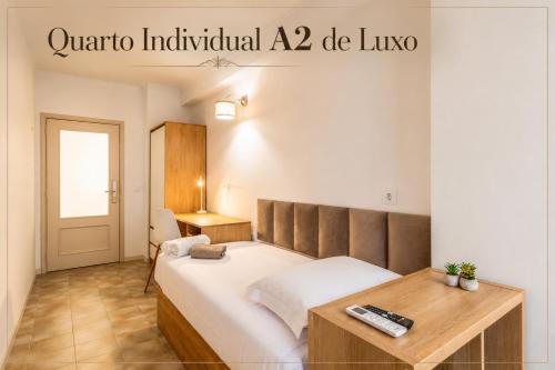 a bedroom with a bed and a desk and a sign at Rooms4you 1 in historic center of Braga in Braga