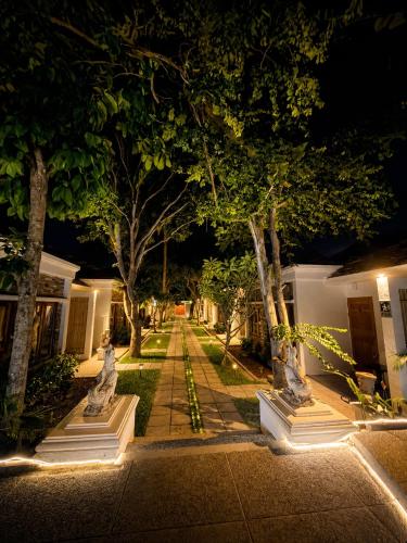 a garden at night with statues and trees at Glory Moon Resort in Bophut