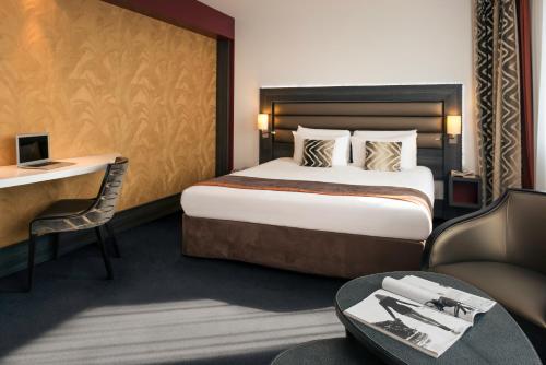 une chambre d'hôtel avec un lit et un bureau dans l'établissement Mercure Lyon Centre - Gare Part Dieu, à Lyon