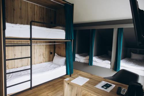 a room with three bunk beds with a desk at Полінарія Козятин in Kozyatyn