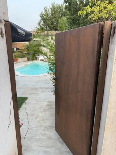 a wooden gate leading to a swimming pool at Location Vacances à Laudun in Laudun