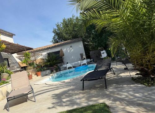 two chairs and a swimming pool in a yard at Location Vacances à Laudun in Laudun