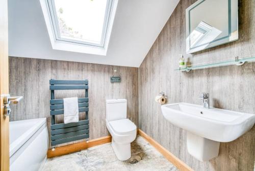 a bathroom with a sink and a toilet and a mirror at Luxury Cottage in the New Forest with Log Burner in Redlynch