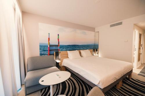 a hotel room with a bed and a chair at Novotel Le Havre Centre Gare in Le Havre