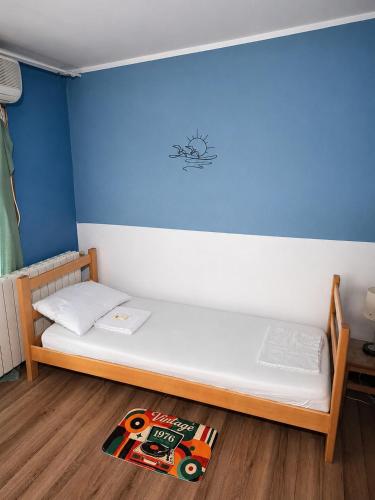 a bed in a room with a blue wall at Hostel Bed&Coffee 360° in Belgrade