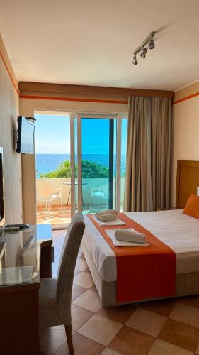 a hotel room with a bed and a view of the ocean at Apartments Deus in Dobra Voda