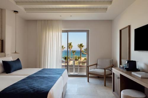 a hotel room with a bed and a view of the ocean at Atlantica Callisto in Ayia Napa