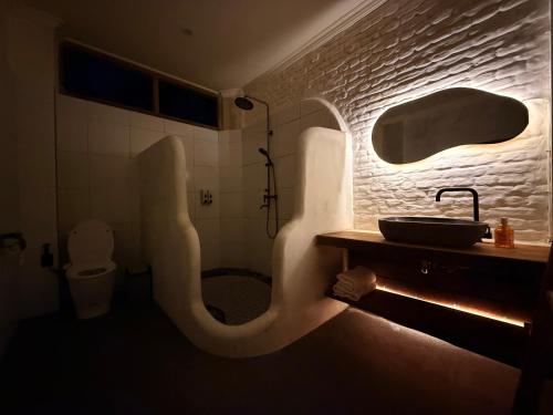 a bathroom with a shower and a sink and a toilet at Mu Homestay Tetebatu in Tetebatu