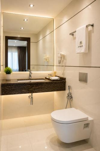 a bathroom with a toilet and a large mirror at Attawfeek Plaza in Tripoli