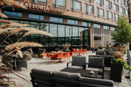 a patio with tables and chairs in front of a building at Solo Sokos Hotel Paviljonki in Jyväskylä