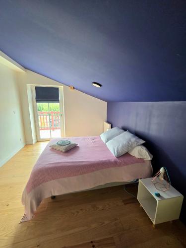 a purple bedroom with a bed and a window at Chambre d'hôtes Ahetzina in Ahetze
