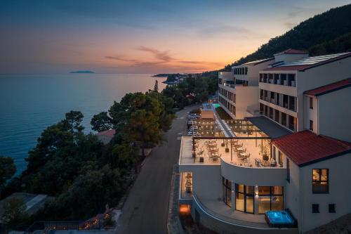 an aerial view of a hotel and the ocean at sunset at Aminess Alfir Hotel in Blato