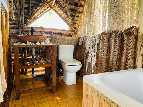a bathroom with a toilet and a sink and a tub at Peace House Zanzibar in Bwejuu