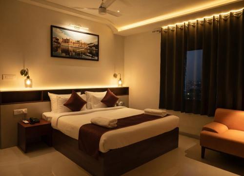 a bedroom with a large bed and a chair at Hotel Layover Stay-3 Minutes From the Airport in Jaipur