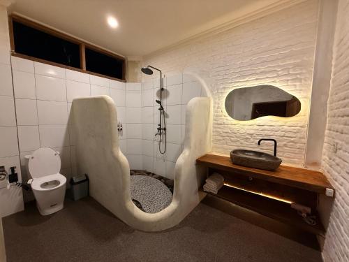 a bathroom with a shower and a toilet in it at Mu Homestay Tetebatu in Tetebatu