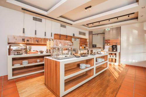 a large kitchen with a counter with food at Hotel Hanioti Village Spa in Hanioti