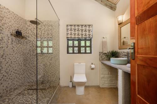 a bathroom with a toilet and a glass shower at Glen Harry Game Reserve in Graaff-Reinet