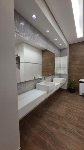 a bathroom with three sinks and two mirrors at Hotel Planalto 2 in Governador Valadares