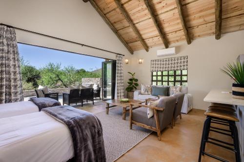a bedroom with a bed and a living room at Glen Harry Game Reserve in Graaff-Reinet