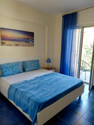a bedroom with a bed with blue sheets and a window at SANT'ALESSIO BEACH HOLIDAY in SantʼAlessio Siculo