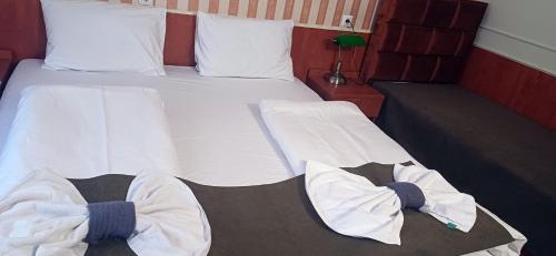 a bedroom with a bed with white sheets and pillows at Atlantic Hotel in Budapest