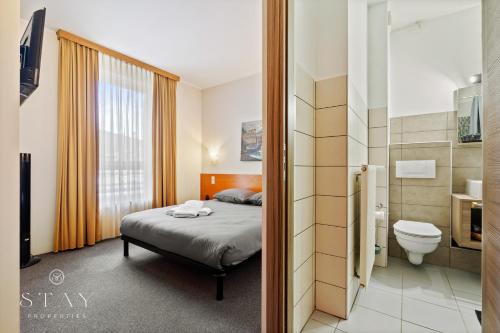 a hotel room with a bed and a toilet at Hotel Stay Properties in Luxembourg