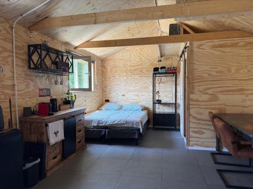 a bedroom with a bed in a room with wooden walls at B&B Tinkunakama in Ouddorp