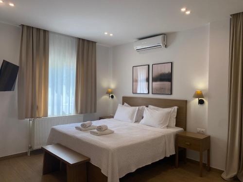 a bedroom with a bed with two towels on it at Ξενώνας Λίθος in Kato Loutraki
