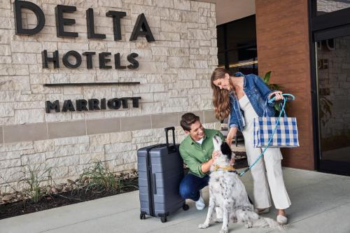a man and a woman with a dog and luggage at Delta Hotels by Marriott Bristol City Centre in Bristol