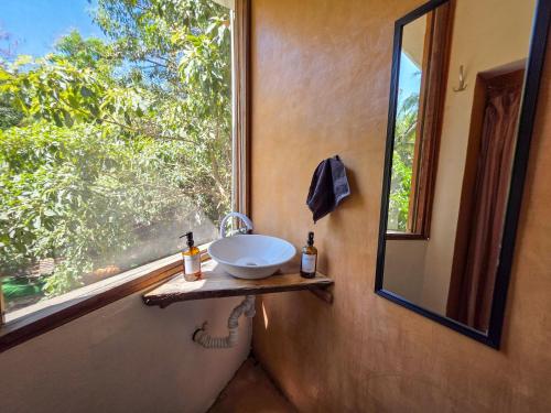 a bathroom with a sink and a window at Zipolite Maracuya Hostel & Rooms in Zipolite
