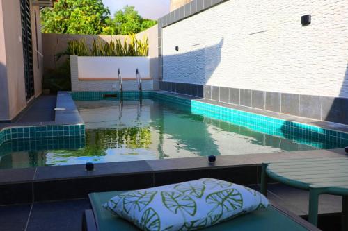 a pool with a table and a mattress in the water at Dream Assinie V in Mafia