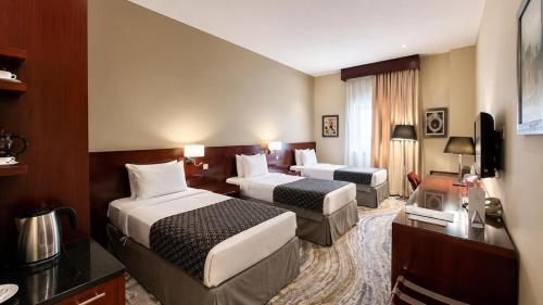 a hotel room with two beds and a television at Makarem Mina Hotel in Mecca