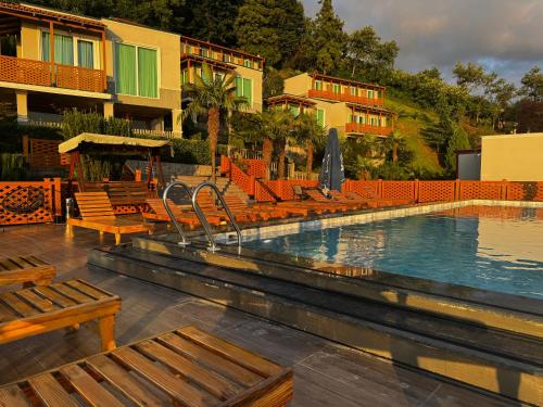 a swimming pool with chairs and a hotel at Green Hills Batumi in Batumi