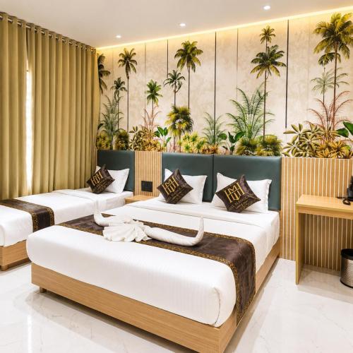 two beds in a room with plants on the wall at Hotel Mangla Inn - Dwarka in Dwarka