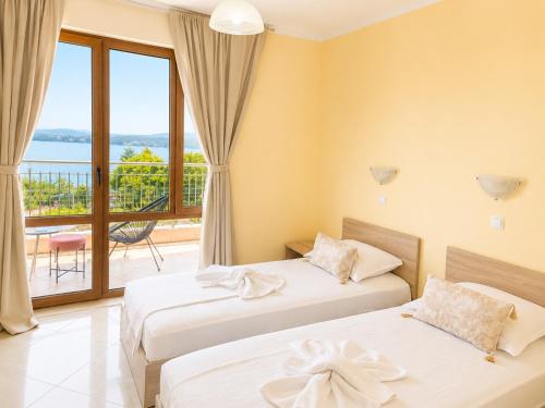 two beds in a room with a balcony at Stefaniya Apartments in Sozopol