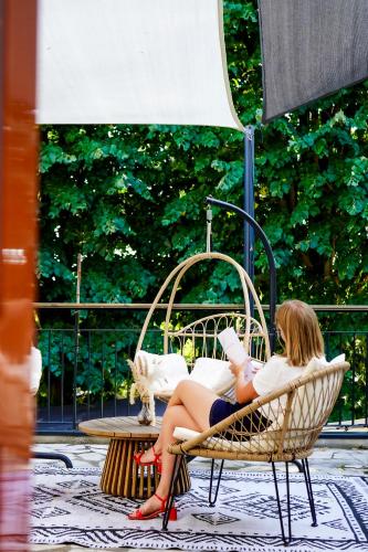 a woman sitting in a chair reading a book at Quintessia in Orvault