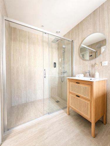 a bathroom with a shower with a sink and a mirror at Le Clos Langevin in Épernay