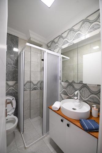 a bathroom with a sink and a shower and a toilet at Rijeka Pansiyon in Ayvalık