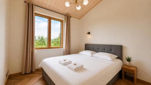 a bedroom with a bed with two towels on it at Kaasaegne puhkemaja in Kersalu