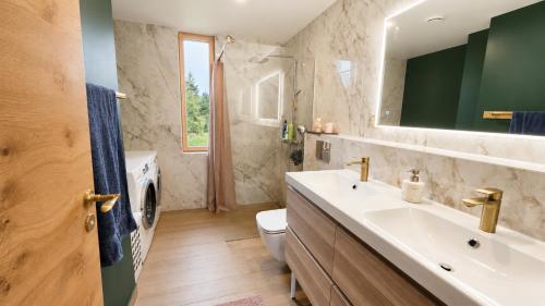 a bathroom with a sink and a toilet and a mirror at Kaasaegne puhkemaja in Kersalu