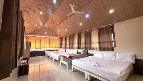 a room with four beds and a ceiling fan at Chirooss Homestays And Resorts in Chikmagalūr