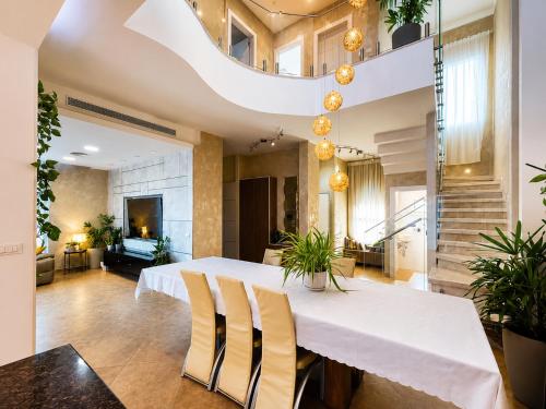 ein Esszimmer mit einem weißen Tisch und Stühlen in der Unterkunft וילת אתרוג - וילה וצימר מושלמים עם בריכה באשלים in Ashalim